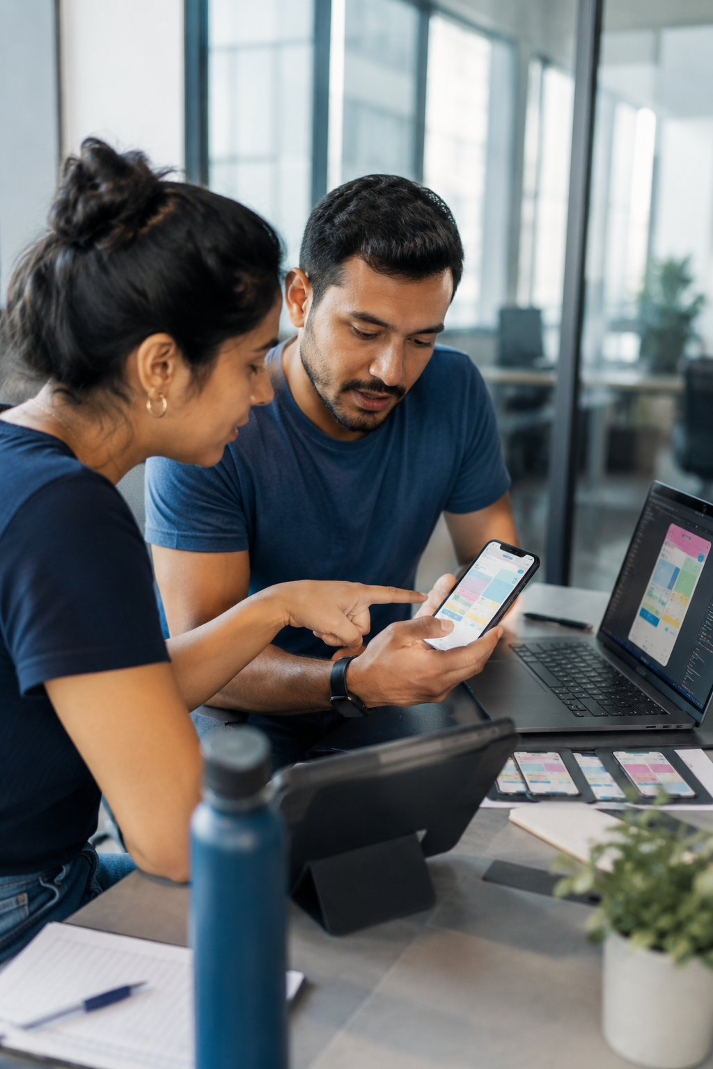 Mobile development team working across devices in a modern office